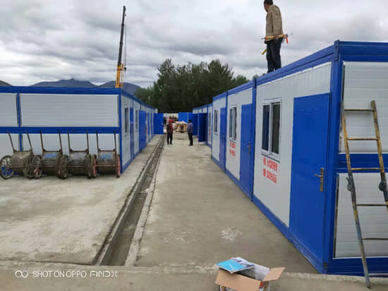 安装师傅站在折叠箱房顶部，该型房屋每平方抗重性为200kg