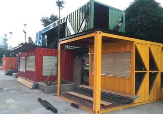 绿色箱房骑在红色与黄色箱式活动房的头上，真是一桩美丽的的风景线呀